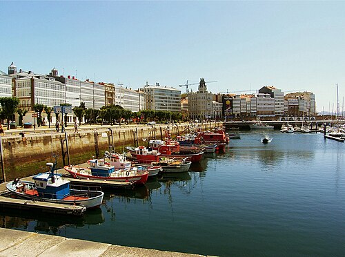 Galerías acristaladas de los edificios de viviendas de la avenida de la Marina junto a la dársena con barcos de pesca en A Coruña