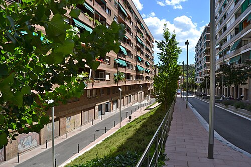 Bloques de viviendas y calle arbolada con zona ajardinada en el distrito de Nou Barris, en Barcelona