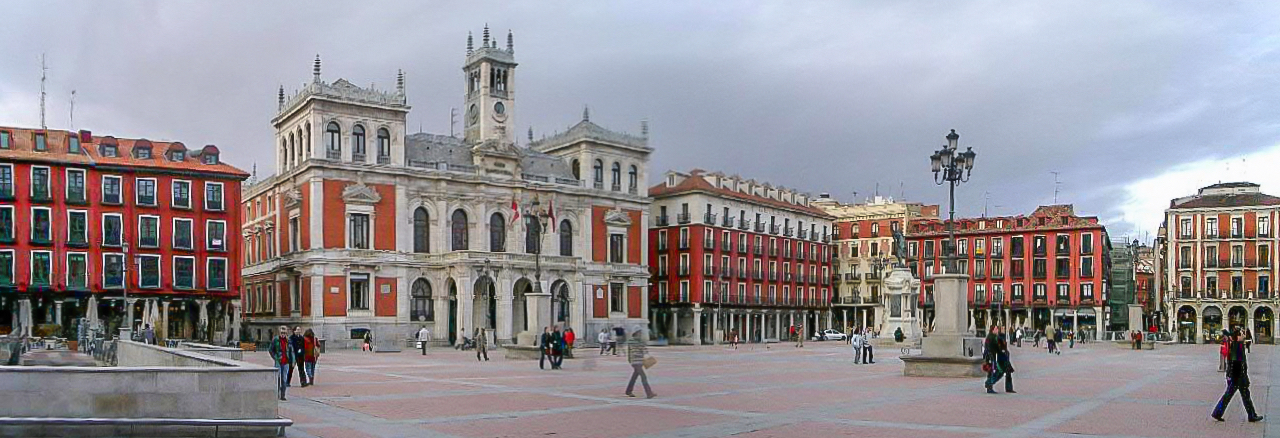 Plaza Mayor de Valladolid con el Ayuntamiento, la estatua del conde Ansúrez y los edificios porticados de viviendas de color rojo