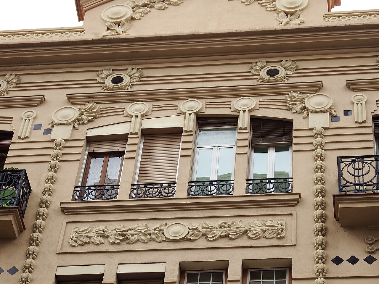 Fachada modernista con balcones de forja en un edificio de viviendas de Valencia