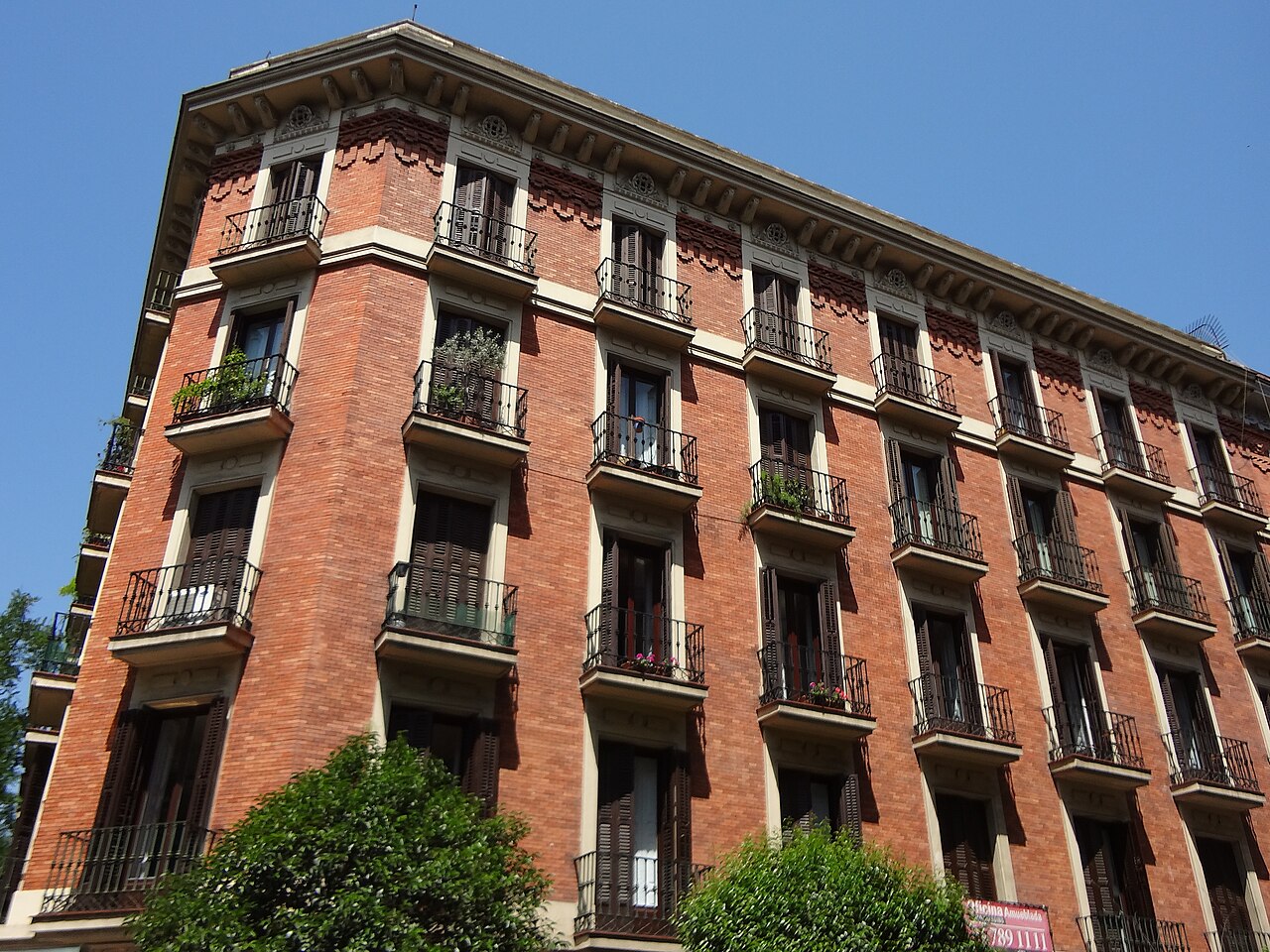 Fachada de ladrillo de un edificio de viviendas con balcones en Madrid