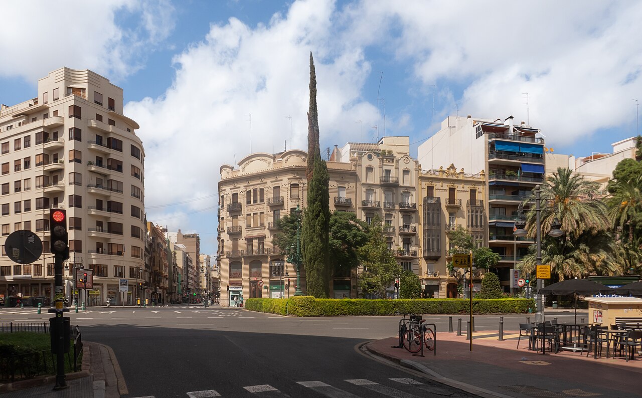 Plaza con edificios de pisos y una palmera en Valencia